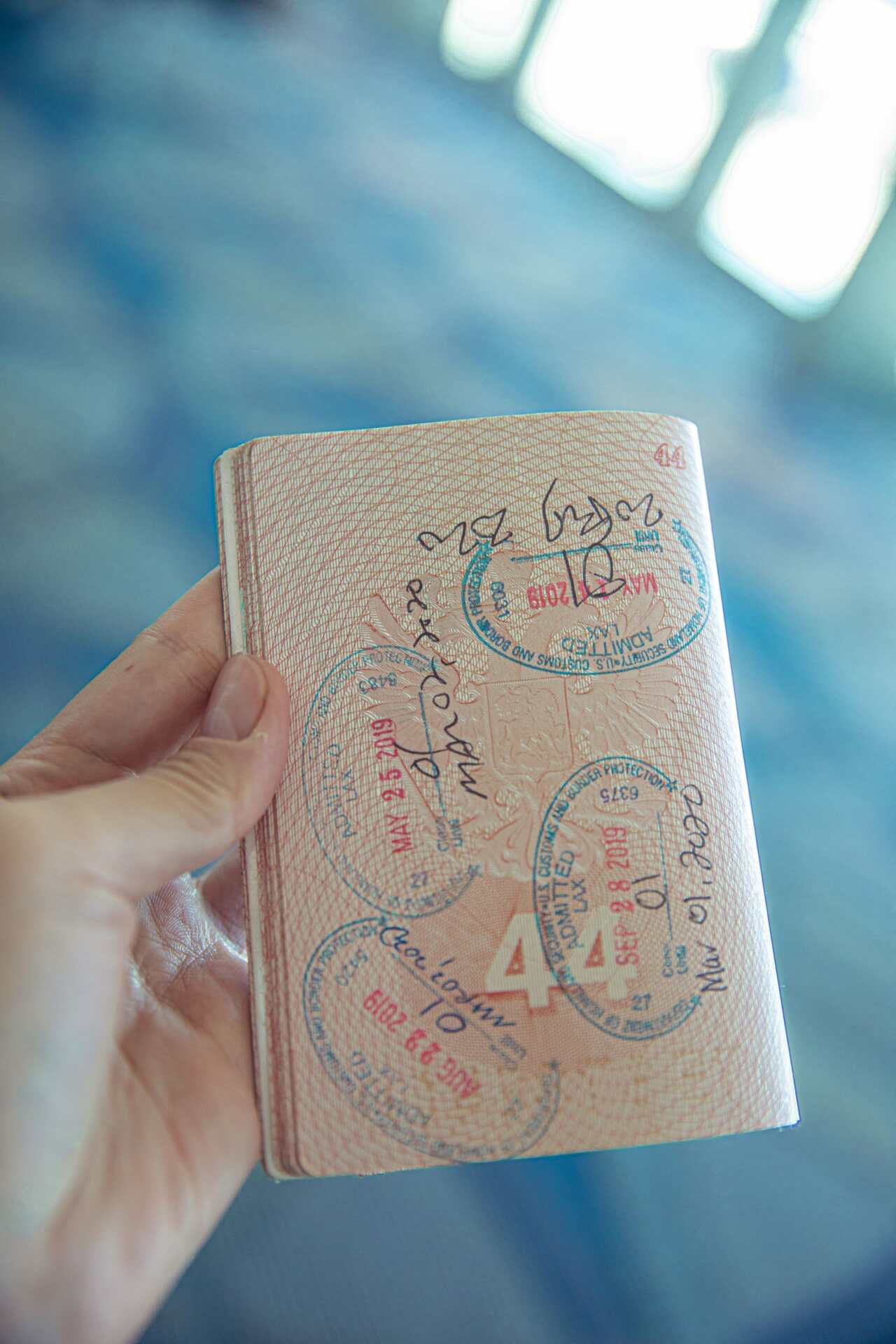 Close-up of a passport open to pages covered in travel and visa stamps